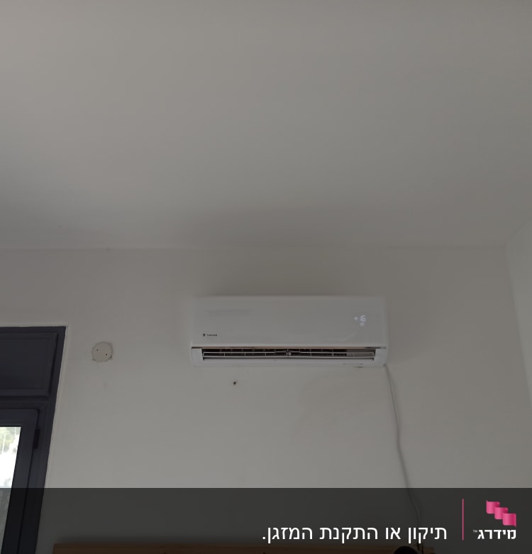 מזגן מותקן על קיר לבן עם תצוגה דיגיטלית